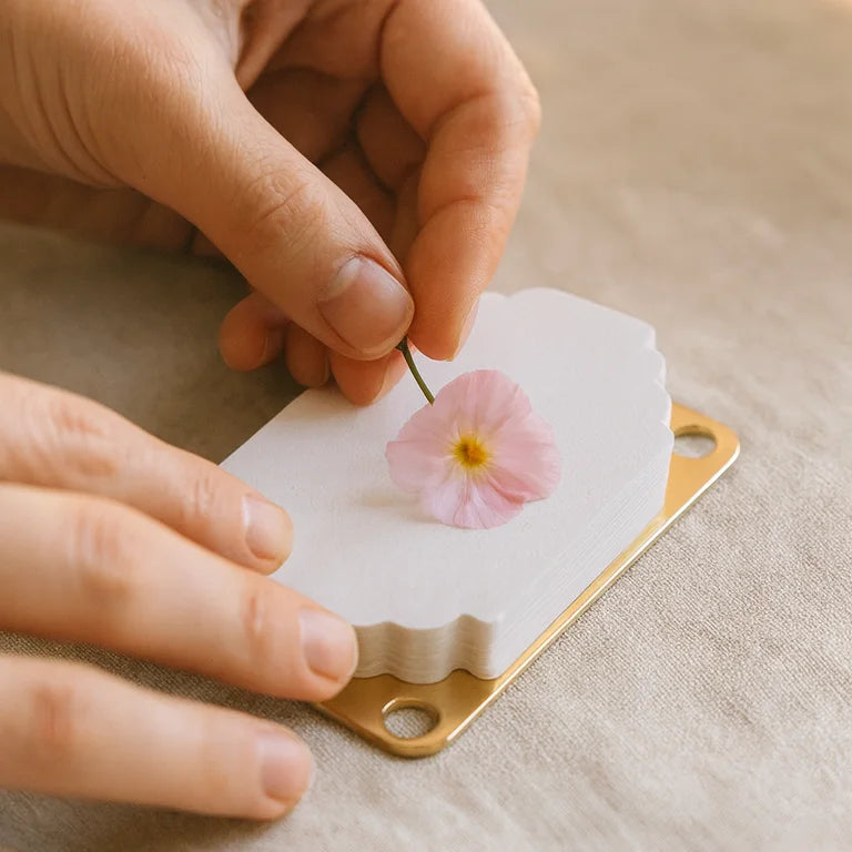 Hands placing a small flower on the absorbent paper
